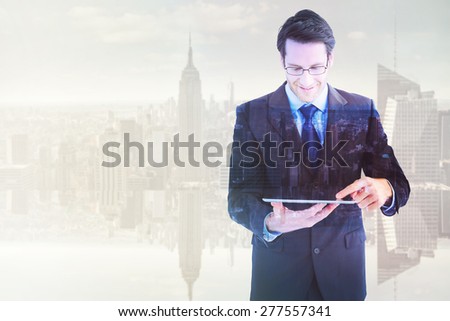 Businessman standing while using a tablet pc against mirror image of city skyline