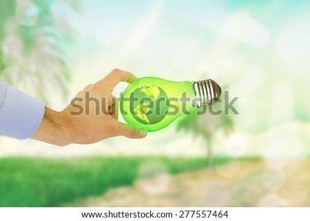 Businessman holding hand out in presentation against light circles on green background