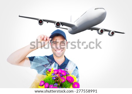 Happy delivery man holding bouquet against graphic airplane