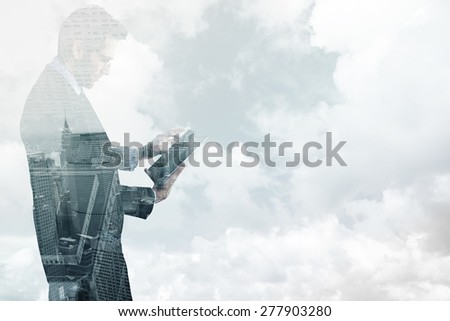 Businessman standing while using a tablet pc against new york skyline