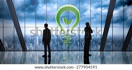 Businessman standing against room with large window looking on city