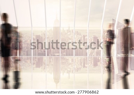 Silhouettes of business people against room with large window looking on city