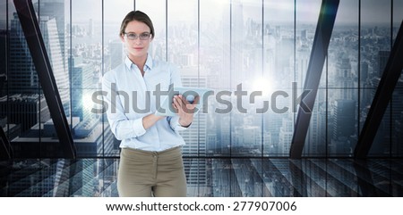 Businesswoman using tablet pc against room with large window looking on city