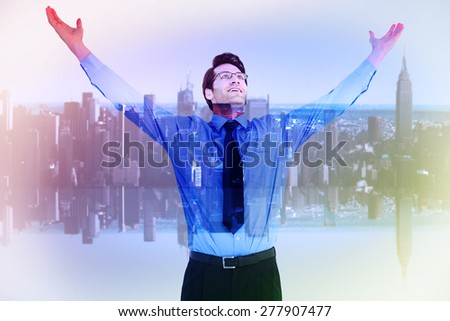 Cheering businessman with his arms raised up against mirror image of city skyline