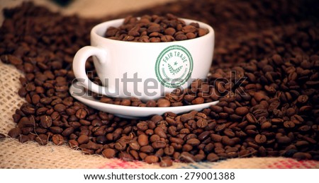 Fair Trade graphic against morning coffee with beans