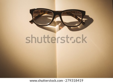 Empty notepad with reading glasses on a desk