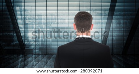 Businessman looking in front of him in suit against room with large window looking on city