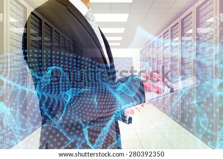 Businessman using his tablet pc against server room with towers
