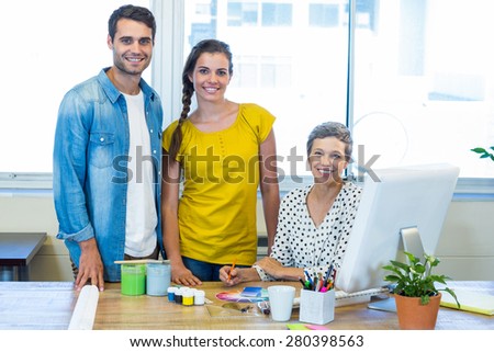 Casual business team smiling at camera during meeting in the office