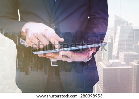 Mid section of a businessman touching digital tablet against mirror image of city skyline
