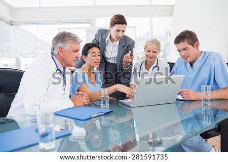 Team of doctors and businesswoman having a meeting in medical office