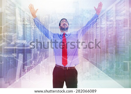 Happy cheering businessman raising his arms against server room with towers