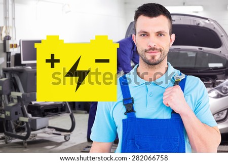 Repairman holding adjustable wrench against mechanic leaning on a car looking at the engine