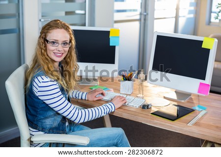 Smiling designer sitting at her desk in the office