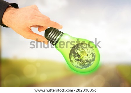 Businessman measuring something with these fingers against orange abstract light spot design