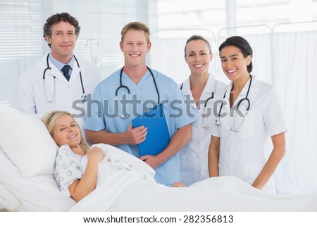 Team of doctor and patient looking at camera in hospital