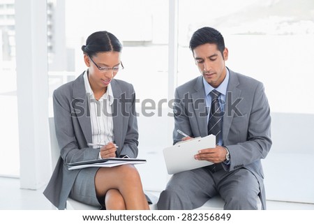 Two young business people in board room meeting at office