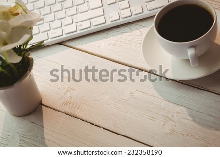 White keyboard and cup of coffee on a desk