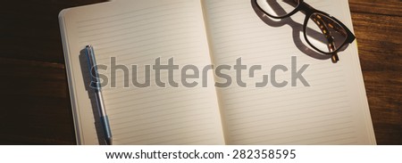 Empty notepad with reading glasses on a desk