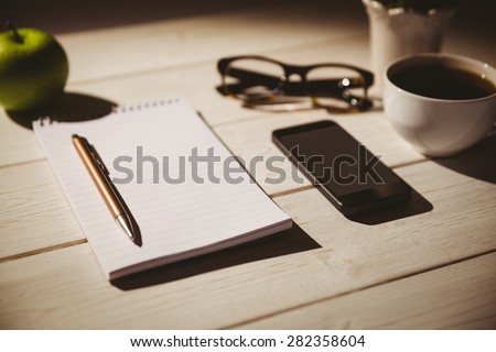 Overhead shot of notepad and smartphone on a desk