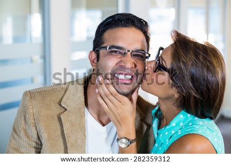 Beautiful brunette kissing her boyfriend in the office