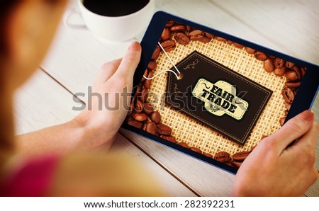 Woman using tablet pc against fair trade label on coffee