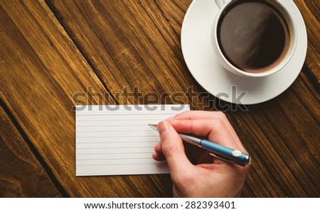Hand writing on the flashcard on a desk