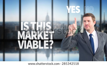 Focused businessman pointing with finger against room with large window looking on city
