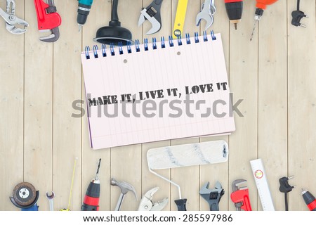 The word make it, live it, love it against tools and notepad on wooden background