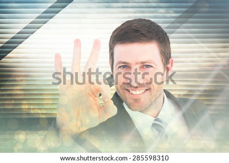 Businessman smiling and making ok sign against window overlooking city