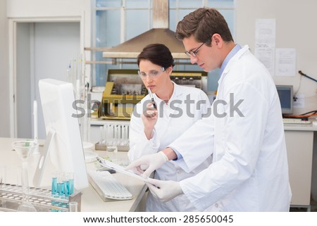 Scientists working attentively with computer in laboratory