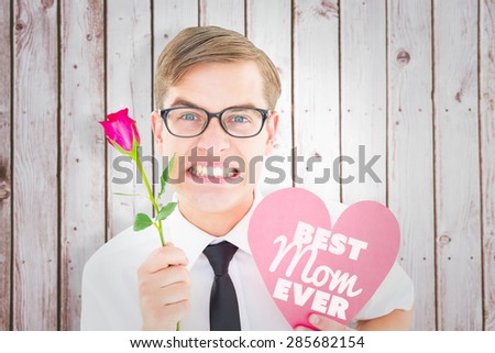 Geeky hipster holding a red rose and heart card against wooden planks