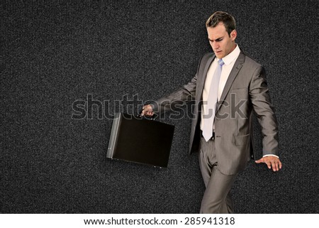 Businessman walking with his briefcase against black background