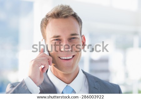 Smiling businessman calling on the phone in the office