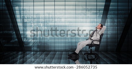 Businessman relaxing in swivel chair against room with large window looking on city
