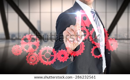 Businessman pointing with his finger against room with large window looking on city