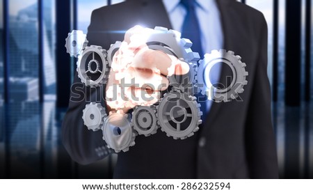 Businessman pointing his finger at camera against room with large window looking on city