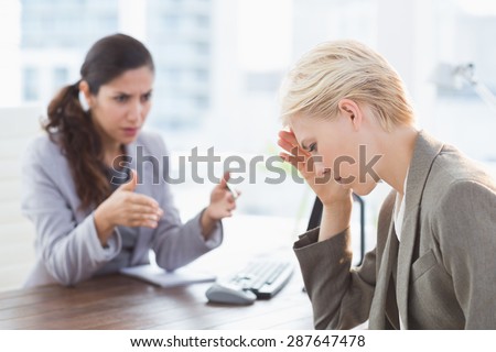 Businesswoman giving orders at her coworker in an office