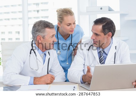 Doctors and nurse working with computer in medical office