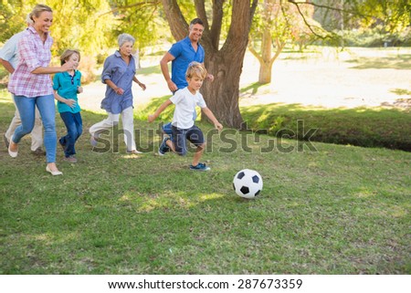 Happy family playing at the ball on a sunny day