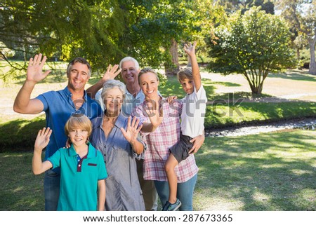 Happy family waving at camera on a sunny day
