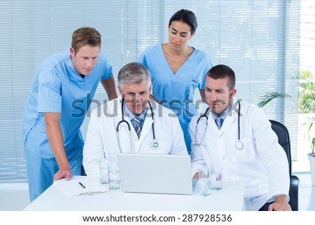 Team of doctors working on laptop in medical office