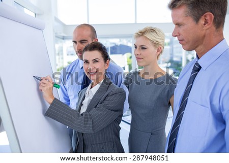 Business people looking at conference board in office