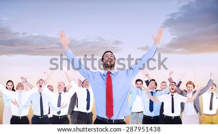 Happy cheering businessman raising his arms against beautiful orange and blue sky