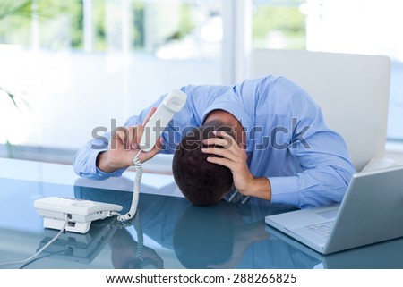 Depressed businessman on the phone in his office