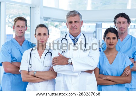 Team of doctors standing arms crossed in the hospital