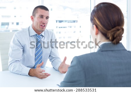 Businessman conducting an interview with businesswoman in an office
