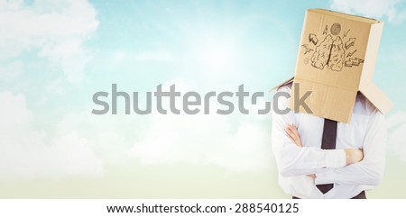 Anonymous businessman with arms crossed against blue sky