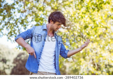 handsome hipster pretend to pay the guitar in a summer day