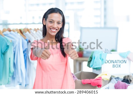 Portrait of a smiling young female volunteer gesturing thumbs up